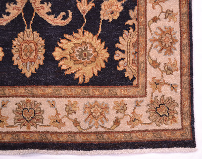 Rug corner detail with dark navy floral medallion and tan ornamental border
