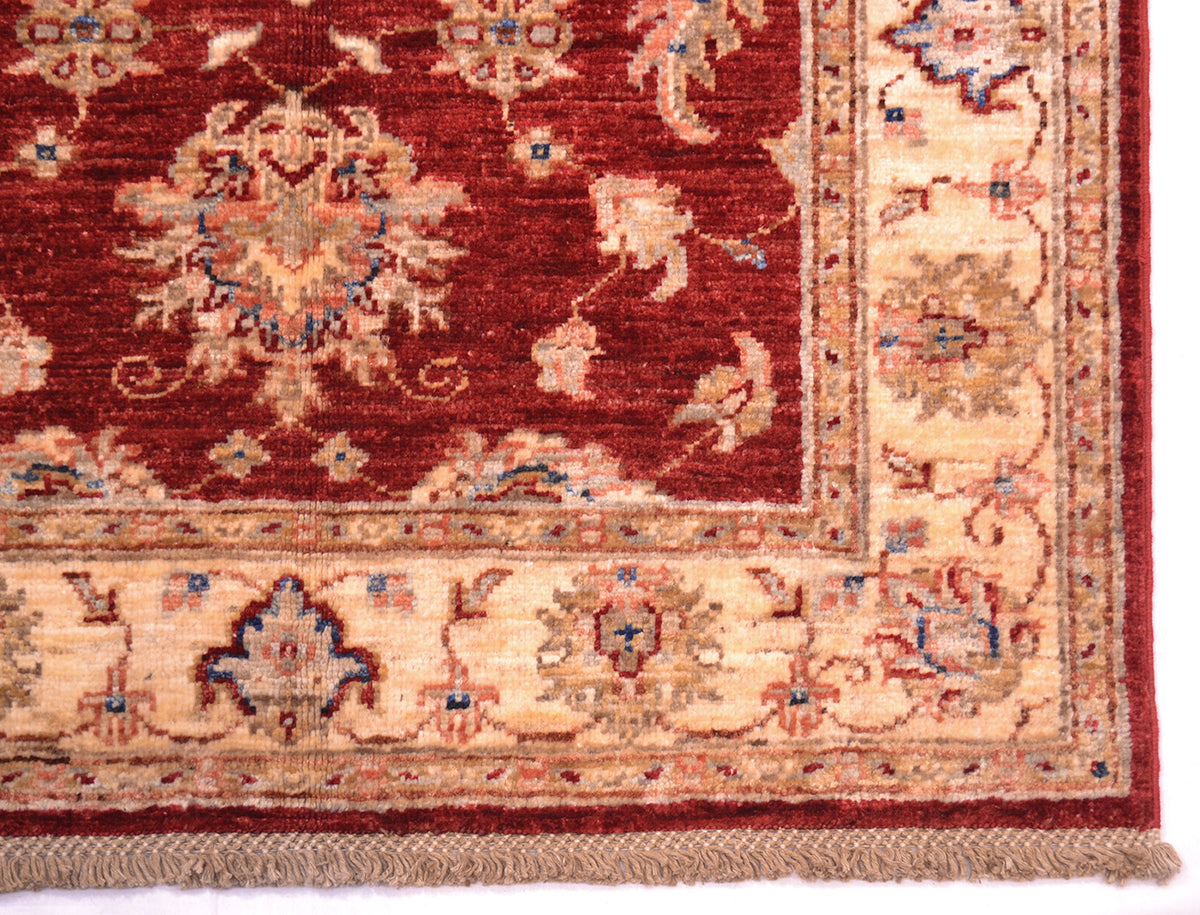 Corner detail and border of Afghan Ziegler rug with decorative floral border and cotton warps tied as lattice detailing.