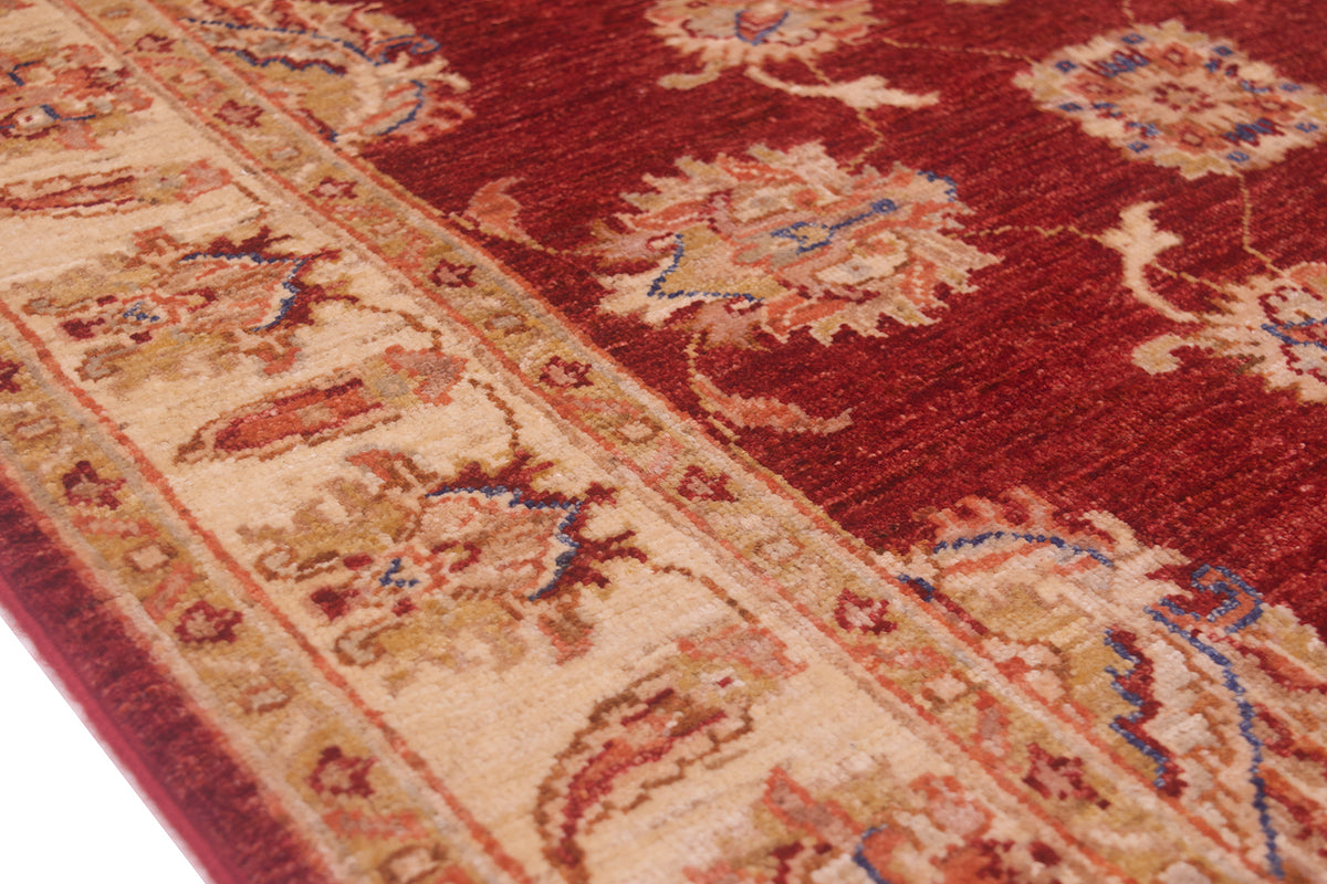 Close up of cream and gold background of border of handknotted rug. Highly decorative floral design.