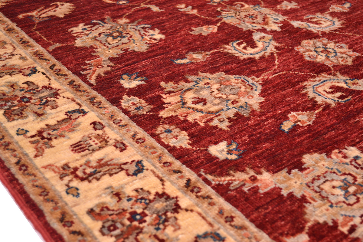 Border of handmade rug in red rusty tons and creamy gold border with palmette and flower border and floral field.