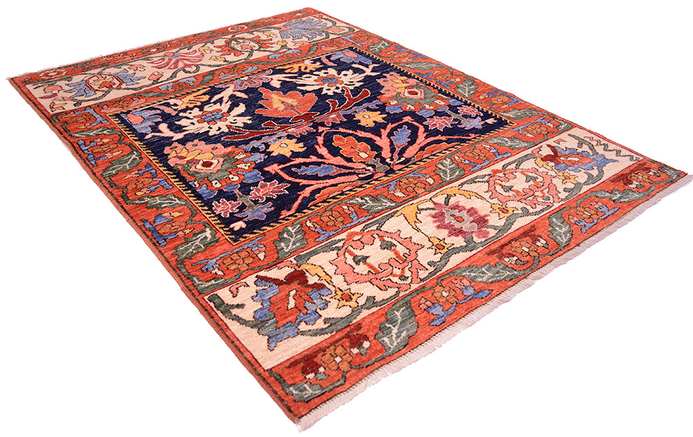 Antique floral area rug with diagonal view, orange border and navy center with cream accents.