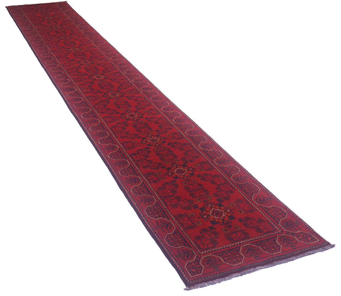 A long red afghan runner rug with a dark navy blue border and central geometric pattern, shown diagonally on a plain white background.