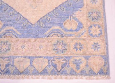 Blue and cream area rug with decorative border and short fringe trim