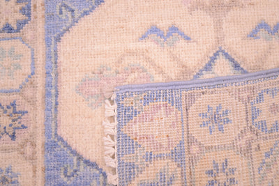 Blue and cream woven rug edge with stitched border and fringe detail