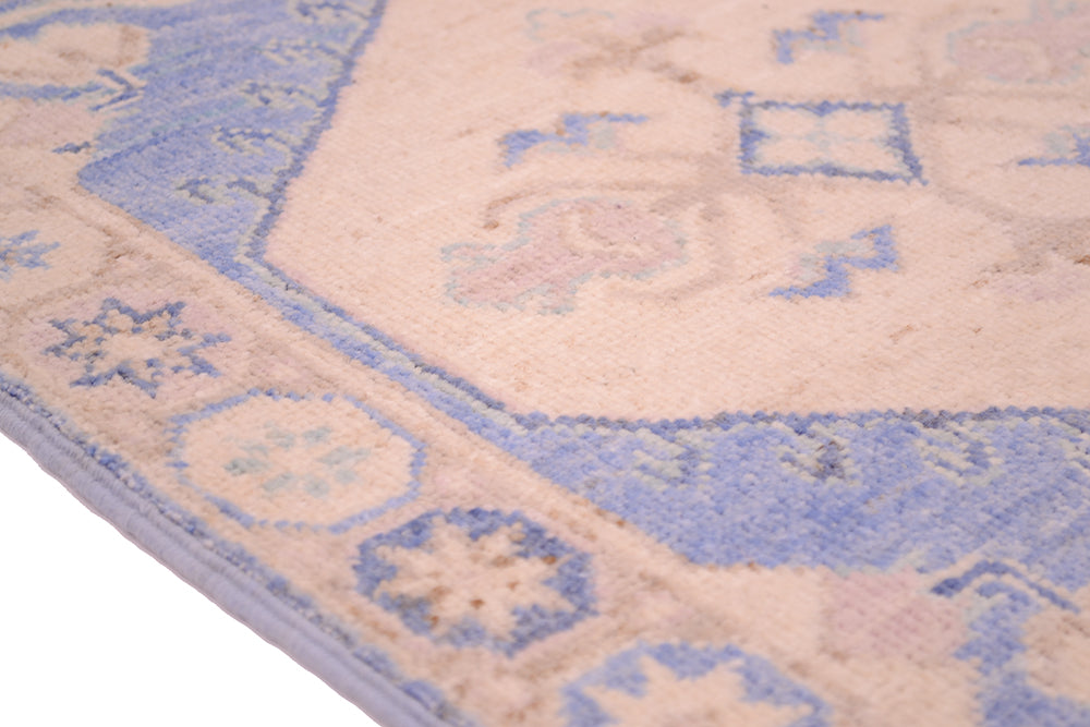 Blue and cream geometric pattern area rug close-up on border and medallion
