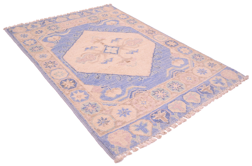 Oushak blue and cream area rug, angled view with border motifs